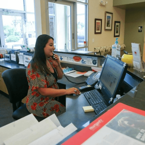 a receptionist at a veterinary clinic is sitting at the front desk